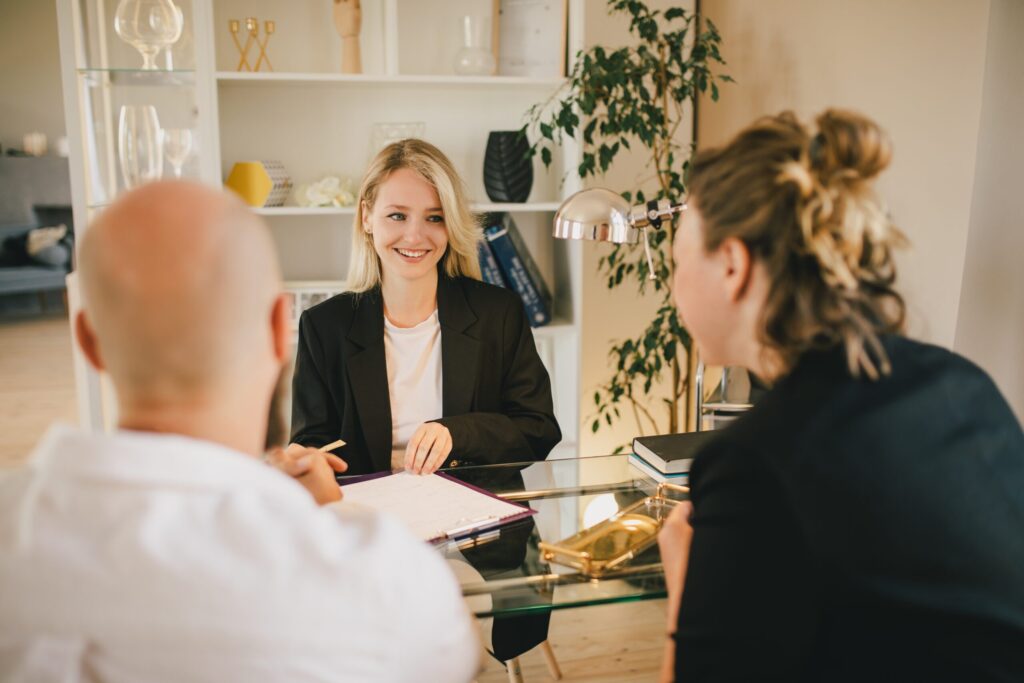 Happy couple having conversation with real financial advisor in the office.